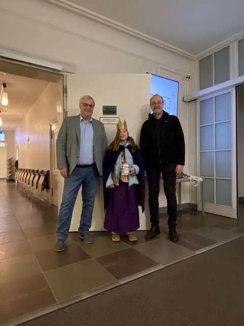 Stephan Dose, Matilda Zydek und Pastor Karsten Winter stehen vor der Rathaustür mit dem Aufdruck 20*C+M+B+25