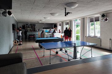 Saal des Jugendzentrums mit Tischtennisplatten und der Theke