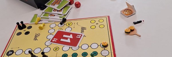 Mensch-ärgere-dich-nicht-Spiel mit Spielfiguren, Skip-Bo- und 11er-raus-Karten, Würfel und Miniaturpizzen auf einem Tisch
