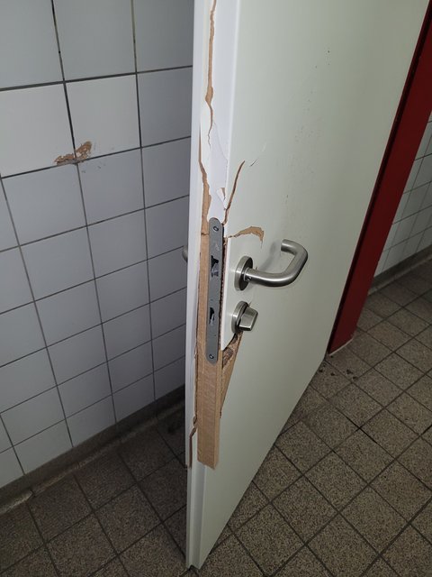 Bild zeigt defekte Toilettentür im Parkhaus aufgrund von Vandalismus