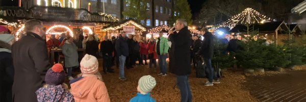 Kinder von hinten vor der Weihnachtspyramide des Schleswiger Weihnachtsmarktes