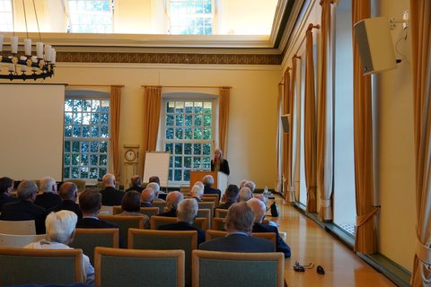 Blick in den Ständesaal des Schleswiger Rathauses zum Sicherheitspolitischen Empfang. Die Zuschauenden sind nur von hinten zu sehen, am Rednerpult steht , Dr. Janka Oertel - Direktorin des Asienprogramms sowie Senior Policy Fellow beim European Council on Foreign Relations, deutsche Politikwissenschaftlerin und Sinologin