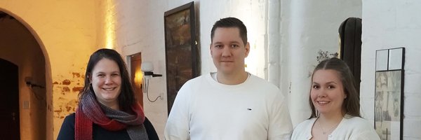 Tahmani Carstensen, Arne Albertsen und Hannah Jürgens mit dem Ausbildungszeugnis im Gang des Grauklosters